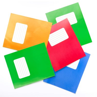 Beyaz arka plan üzerine renkli okul alıştırma kitapları.