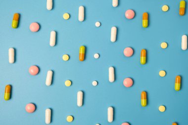 Mavi arkaplanda düzenlenmiş pek çok farklı hapı kapat.