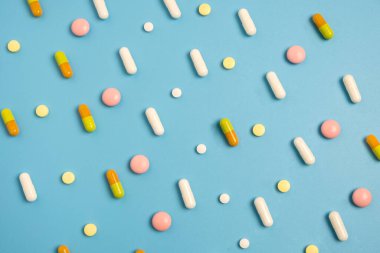 Mavi arkaplanda düzenlenmiş pek çok farklı hapı kapat.