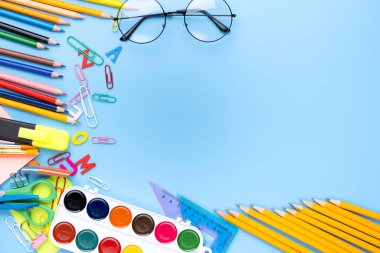 Mavi fotokopi arka planında birçok farklı okul malzemesi var. Okul konseptine dönelim..