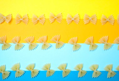 Eriştenin yakın çekim şekli farfalle ayrıca papyon ya da renkli arka plana yerleştirilmiş kelebek makarnası olarak da bilinir..