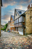 Dinan, Bretagne, Frankreich. Typische alte Fachwerk- und Steinhäuser entlang der Rue du Jerzual, einer alten Kopfsteinpflasterstraße.