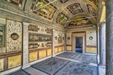Palazzo Te, Mantua, Lombardy, İtalya. Gizli Bahçe 'ye bakan Loggia, duvarlarında ve kasasında değerli süslemeler olan son derece zarif bir yerdir. Nehir çakıl taşlarından yapılmış zemin, Gonzagas 'ın cihazlarıyla süslenmiş..