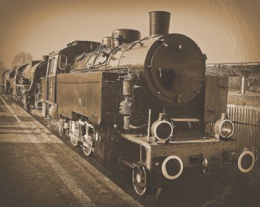 Eski lokomotif tren üzerinde duruyor. Stilize tonda fotoğraf.
