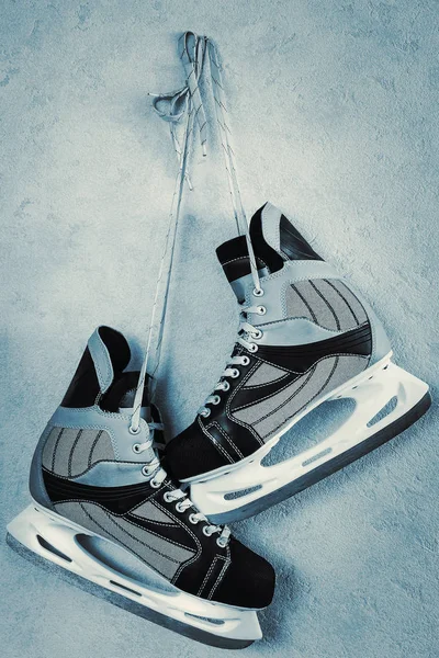 Hockey skates hang on a wall.Cyanotype