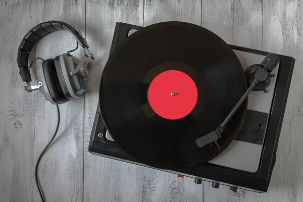 ビニール レコードとヘッドフォンの古いターン テーブルがテーブルの上に置く ロイヤリティフリーのストック写真
