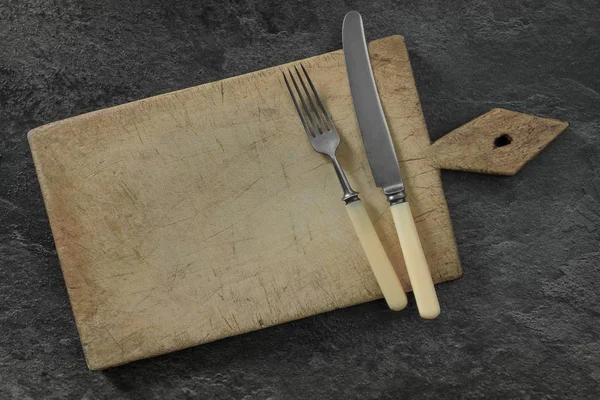 Cutting board with knife and fork — Stock Photo, Image