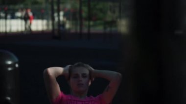Spor sahasında karın kasları üzerinde egzersiz yapan genç bir kadının yakın çekimi.