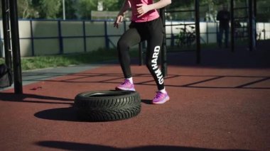 Spor alanında spor yapan genç bir kadın.