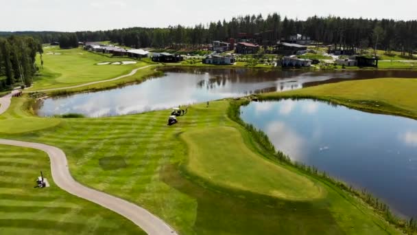 Elektrisk golfbil rider på gräsmattan, antenn utsikt över golfbanan på sommaren — Stockvideo