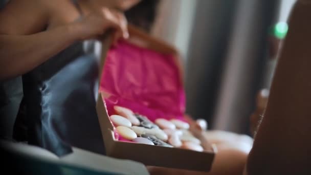 Close-up de uma mulher tomando uma caixa de presente de macaroons variados na festa das galinhas — Vídeo de Stock