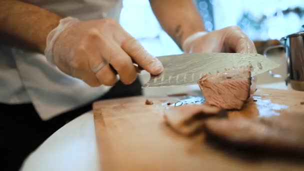 Powolny ruch kucharz w rękawiczkach tnie soczysty stek mięsny na drewnianej desce nożem — Wideo stockowe