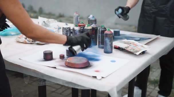 Close-up de pessoas desenhando um quadro com lata de aerossol em um papel fora — Vídeo de Stock