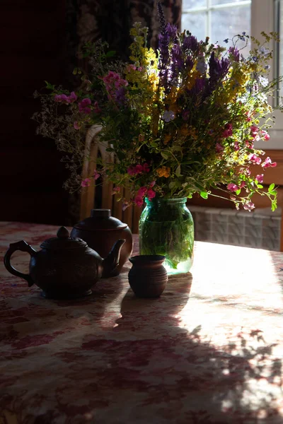 Ramo de flores silvestres sobre la mesa a la luz del sol — Foto de Stock