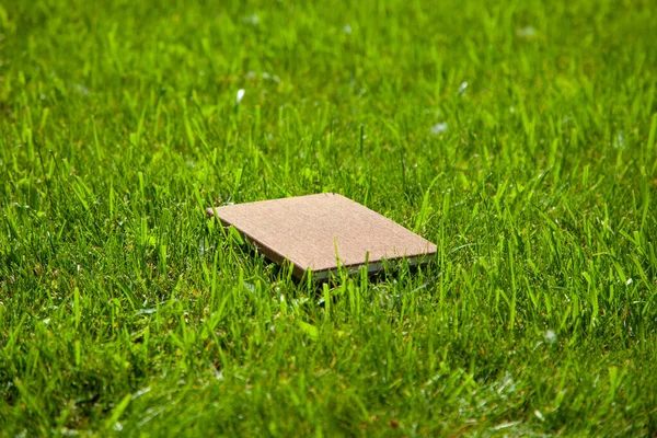 Коричневый Закрытый Блокнот Зеленой Траве Вид Сбоку — стоковое фото