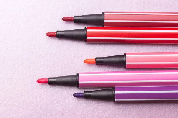 Beş açık işaret ya da pembe, mor, pembe renkli kalem gümüş, gri arka plan, izole edilmiş maket gibi uzanır.