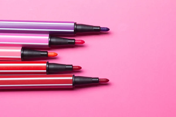ピンク、紫、ピンクの5つの開いたマーカーまたはペンはピンクの背景のステップのように横になり、孤立したモックアップ — ストック写真