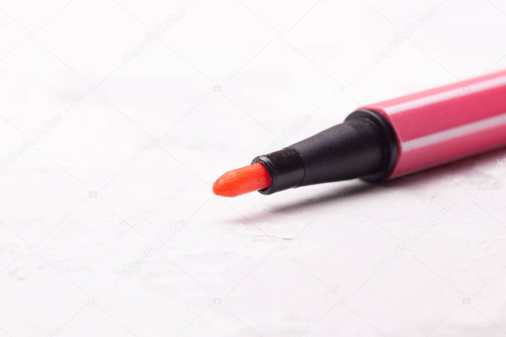 open marker or pen in pink on a white concrete background, close up