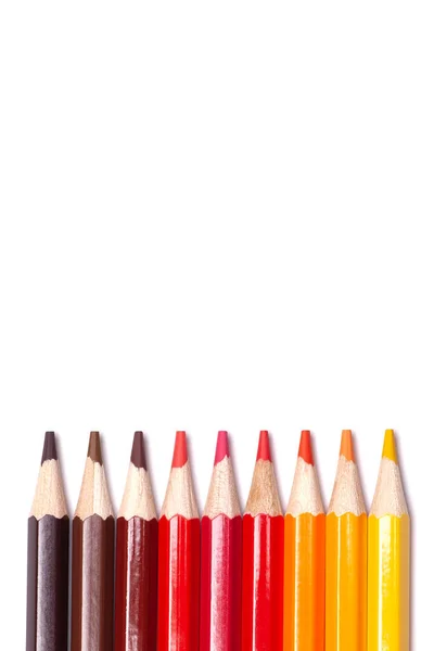Buntstifte aus Holz in Rottönen auf weißem, isoliertem Hintergrund, Herbstfarben, Attrappe, vertikal — Stockfoto