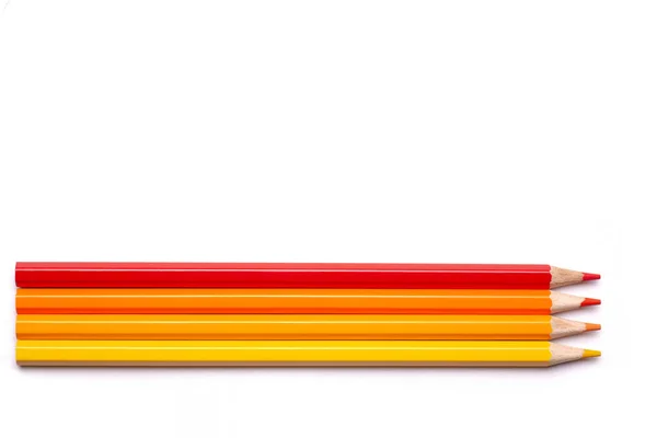 Multi-colored wooden pencils in red shades on a white isolated background, autumn colors, mock up, horizontally — Stock Photo, Image