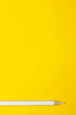 Parlak sarı bir zemin üzerinde dikey beyaz, tahta kalem, izole edilmiş, kopyalama alanı, maket