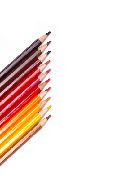 Lápices de madera multicolores en tonos rojos sobre un fondo blanco aislado, colores otoñales — Foto de Stock
