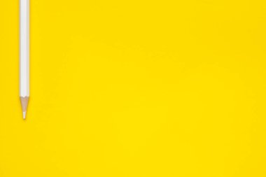 Parlak sarı bir zemin üzerinde yatay beyaz, keskin tahta kalem, izole edilmiş, kopyala uzay, taklit et