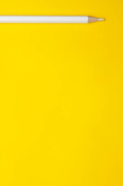 Parlak sarı bir zemin üzerinde dikey beyaz, tahta kalem, izole edilmiş, kopyalama alanı, maket