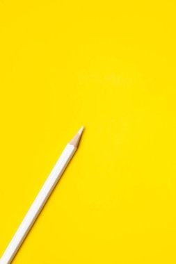 Parlak sarı bir zemin üzerinde köşegen, beyaz, tahta kalem, izole, kopyalama alanı, taklit