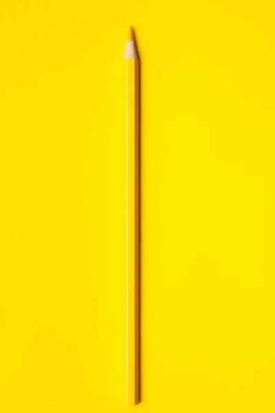 Vertical yellow sharp wooden pencil on a bright yellow background, isolated, copy space, mock up — Stock Photo, Image