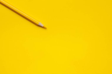 Parlak sarı bir zemin üzerinde köşegen, ahşap kalem, izole edilmiş, kopyalama alanı, taklit