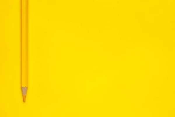 Lápiz de madera afilado amarillo vertical sobre un fondo amarillo brillante, aislado, espacio de copia, se burlan de — Foto de Stock