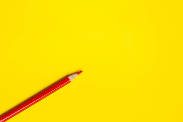 Diagonal red sharp wooden pencil on a bright yellow background, isolated, copy space, mock up — Stock Photo, Image