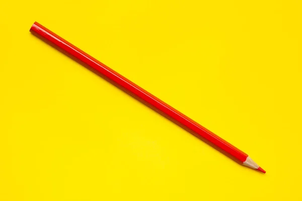 Diagonal red sharp wooden pencil on a bright yellow background, isolated, copy space, mock up — Stock Photo, Image