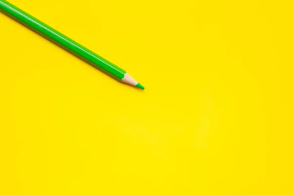 Diagonal green sharp wooden pencil on a bright yellow background, isolated, copy space, mock up — Stock Photo, Image