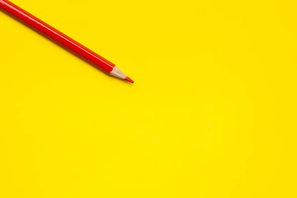 Lápis de madeira afiado vermelho diagonal em um fundo amarelo brilhante, isolado, espaço de cópia, mock up — Fotografia de Stock