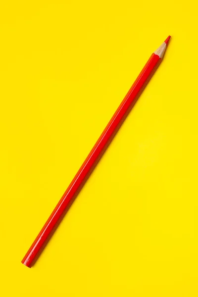 Diagonal red sharp wooden pencil on a bright yellow background, isolated, copy space, mock up — Stock Photo, Image