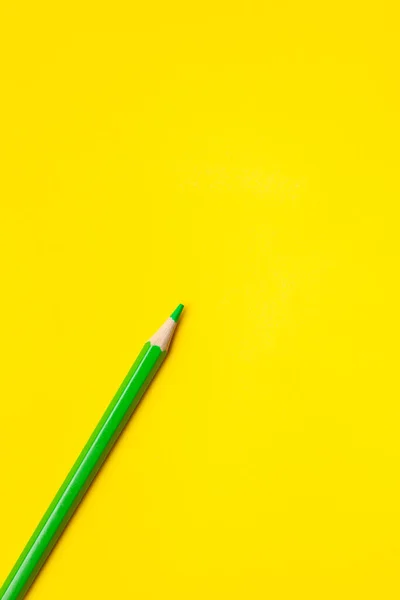 Diagonal green sharp wooden pencil on a bright yellow background, isolated, copy space, mock up — Stock Photo, Image