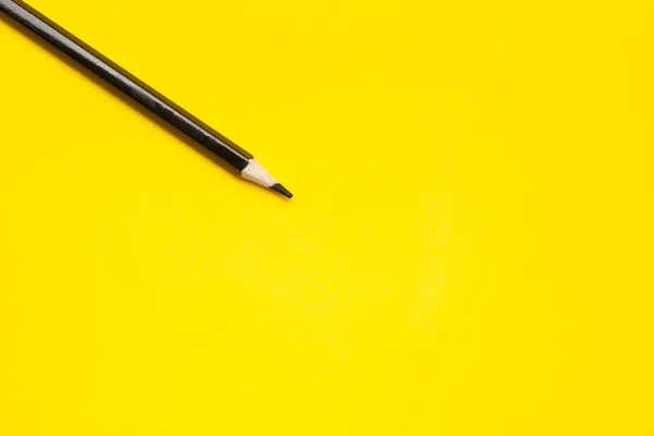 Διαγώνιο μαύρο αιχμηρό ξύλινο μολύβι σε φωτεινό κίτρινο φόντο, απομονωμένο, αντίγραφο χώρου, mock up — Φωτογραφία Αρχείου
