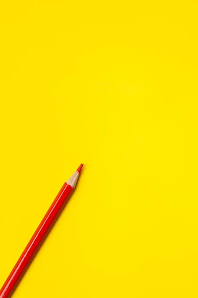 Lápis de madeira afiado vermelho diagonal em um fundo amarelo brilhante, isolado, espaço de cópia, mock up — Fotografia de Stock