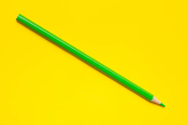 Diagonal green sharp wooden pencil on a bright yellow background, isolated, copy space, mock up — Stock Photo, Image