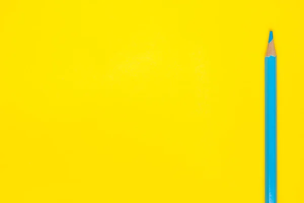 Lápiz de madera afilado azul vertical sobre un fondo amarillo brillante, aislado, espacio de copia, se burlan de — Foto de Stock