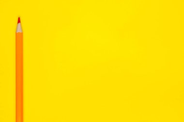 parlak sarı bir zemin üzerinde dikey turuncu, tahta kalem, izole, kopyalama alanı, taklit