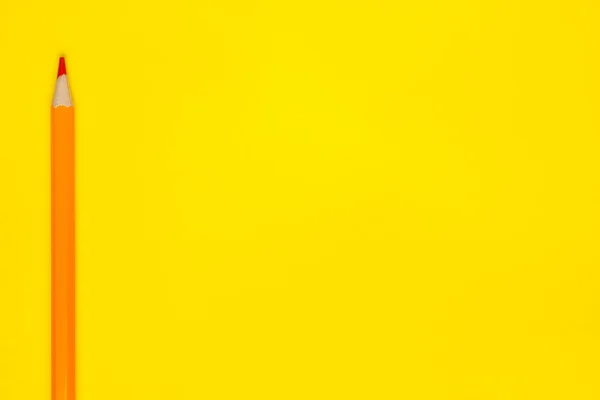 Matita di legno tagliente arancio verticale su uno sfondo giallo brillante, isolato, spazio copia, modellare — Foto Stock