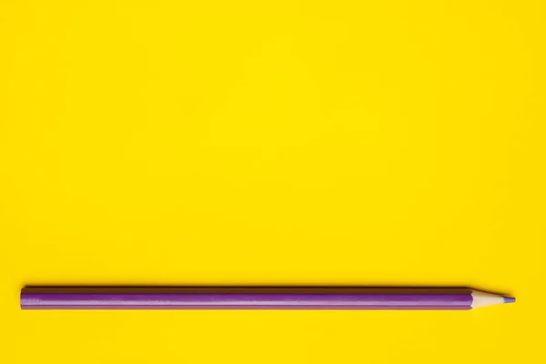 Horizontální fialová ostrá dřevěná tužka na jasně žlutém pozadí, izolované, kopírovací prostor, maketa — Stock fotografie