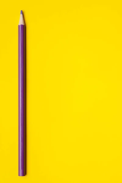 밝은 노란색 배경에 있는 수직 자줏빛의 날카로운 나무 연필, 따로 떨어져 있는 복사 공간, — 스톡 사진