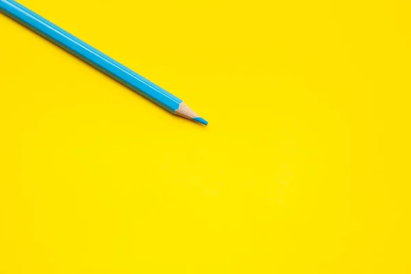 Diagonal blue sharp wooden pencil on a bright yellow background, isolated, copy space, mock up — Stock Photo, Image