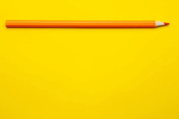 Lápiz de madera afilado naranja horizontal sobre un fondo amarillo brillante, aislado, espacio de copia, se burlan de — Foto de Stock