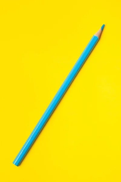 Diagonal blauer scharfer Holzstift auf leuchtend gelbem Hintergrund, isoliert, Kopierraum, Attrappe — Stockfoto