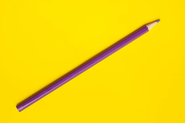 Lápis de madeira afiada roxo diagonal em um fundo amarelo brilhante, isolado, espaço de cópia, mock up — Fotografia de Stock